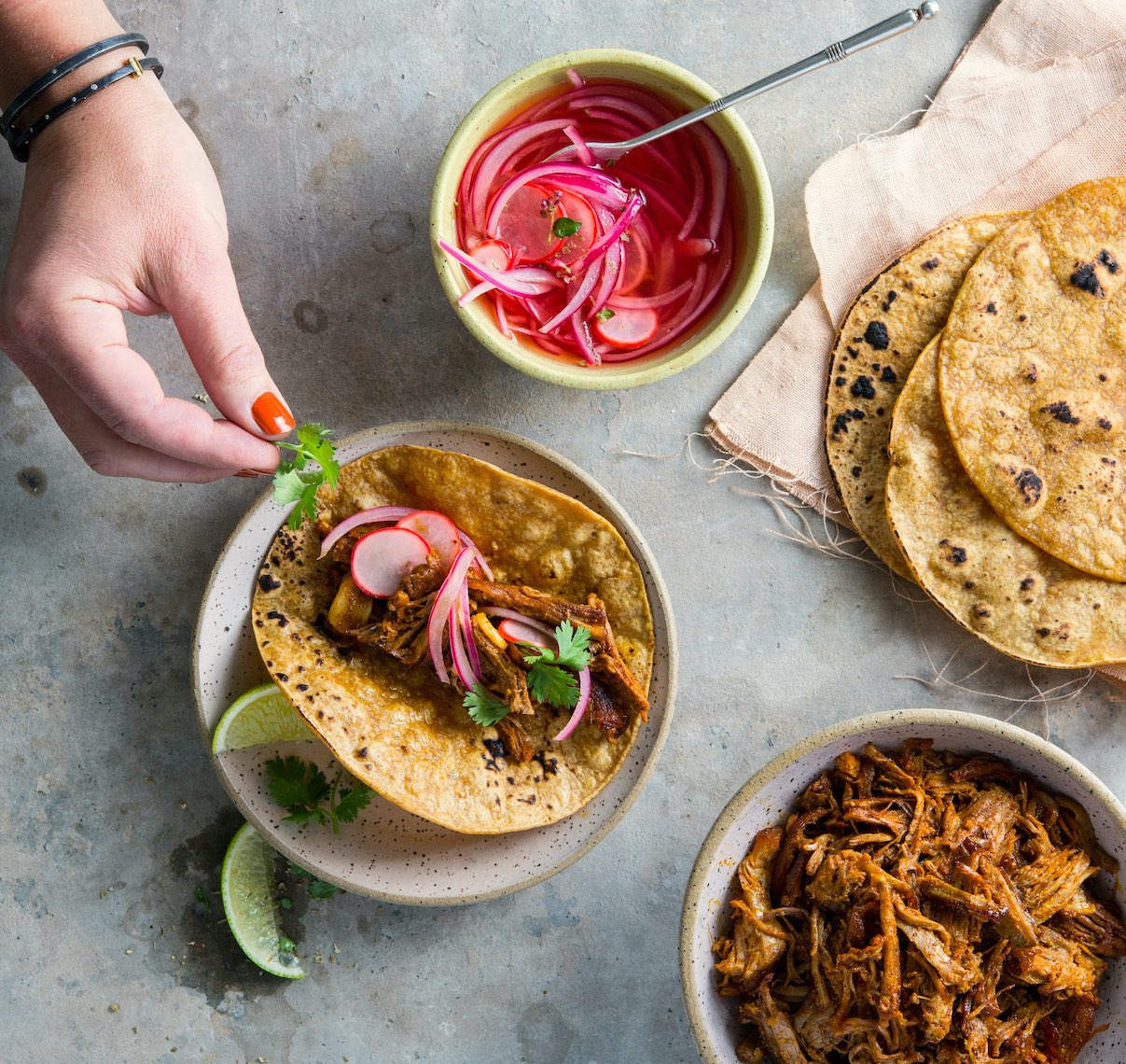Tacos and hand with orange polish by commercial food photographer Sarah Flotard  
